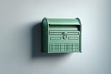 Vintage green wall-mounted mailbox against a light gray wall.