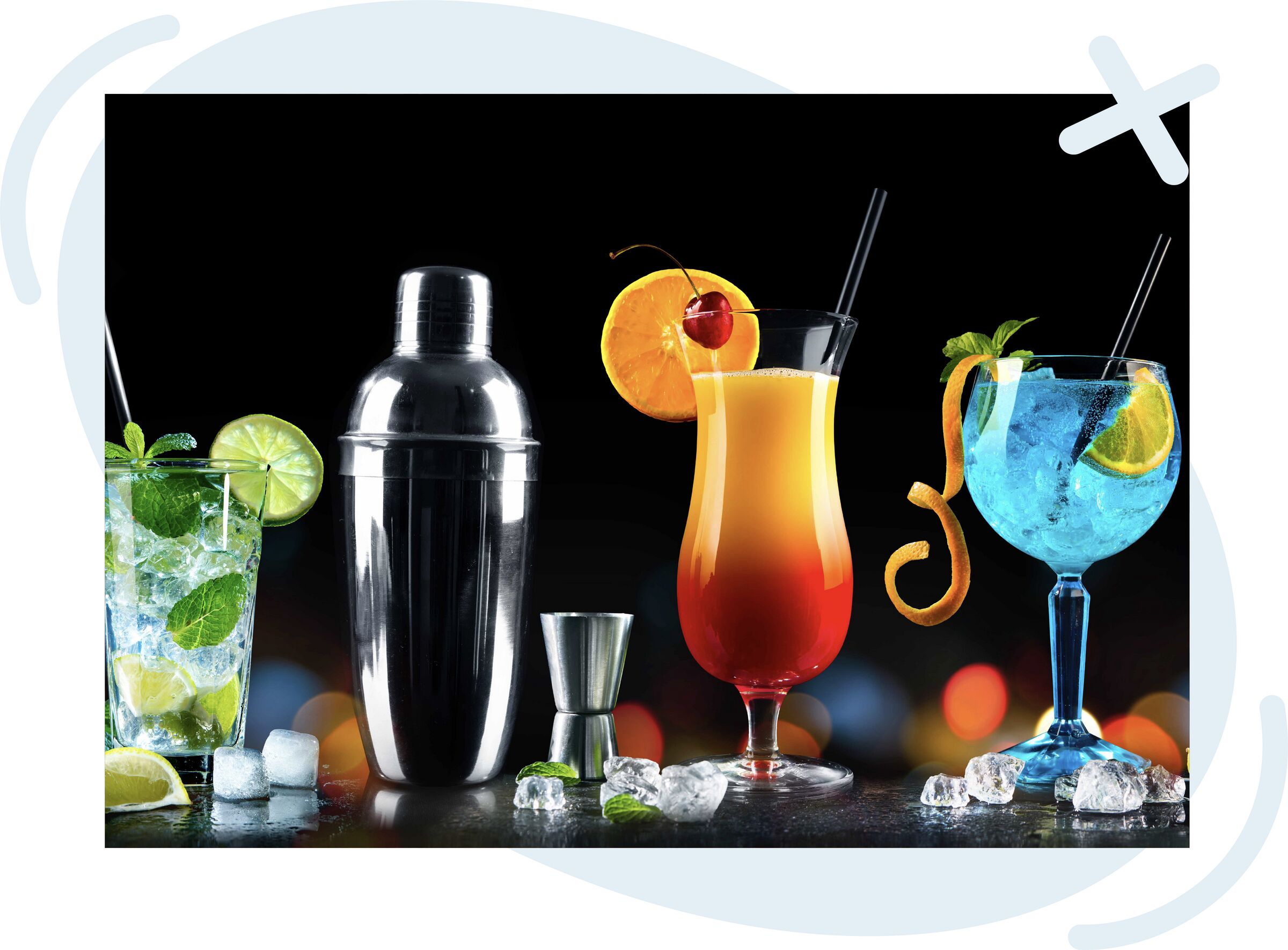 Colorful cocktail setup with shaker and garnished drinks on a dark background.