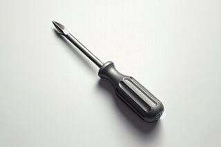 Gray Phillips-head screwdriver on a light surface, shown at an angle with soft shadows.