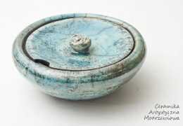 Round turquoise ceramic jar with a fitted lid and small notch, displayed on a white background