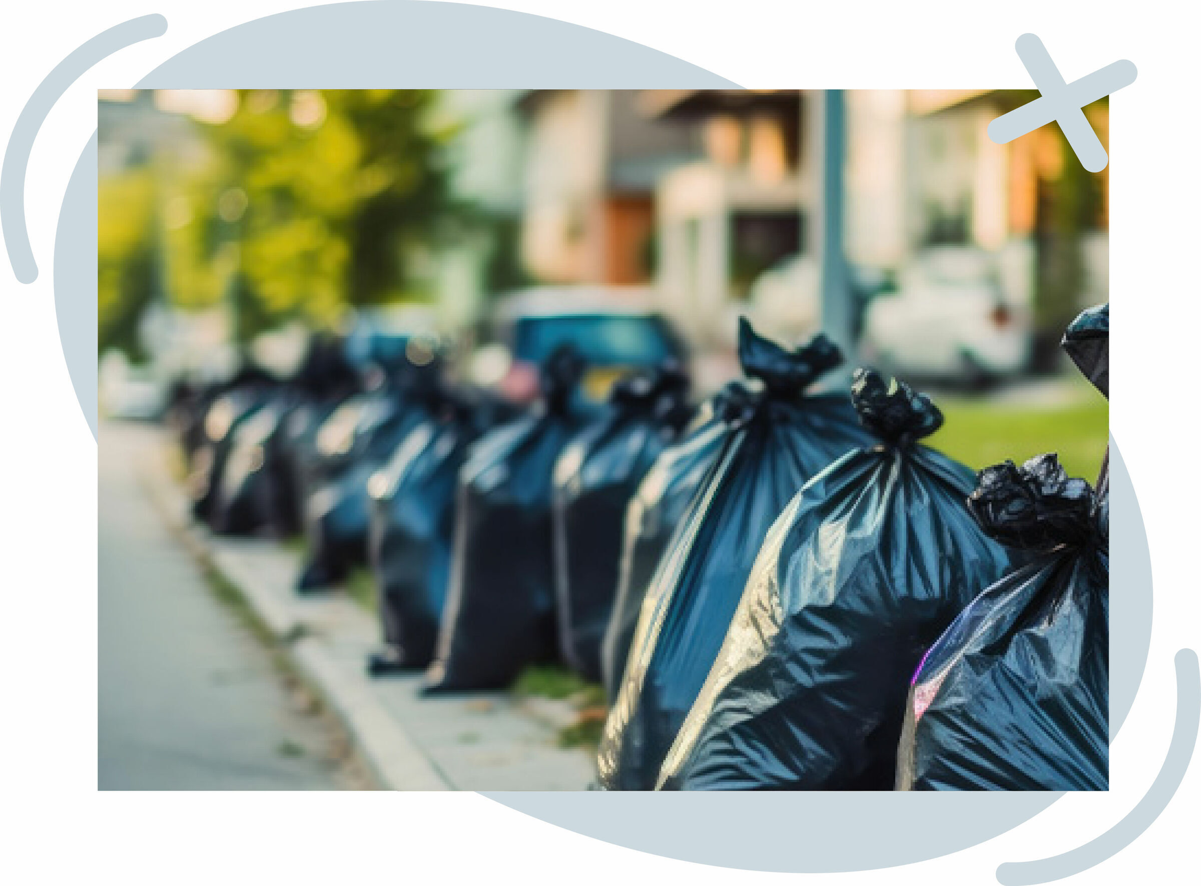 Row of tied black garbage bags lined up along a residential curb on pickup day.