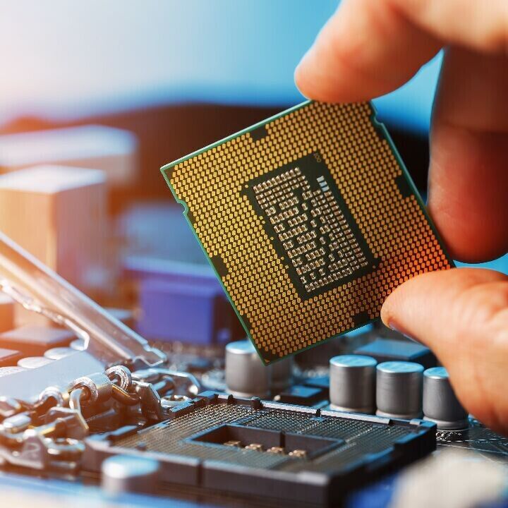 Hand installing a computer CPU onto a motherboard socket.