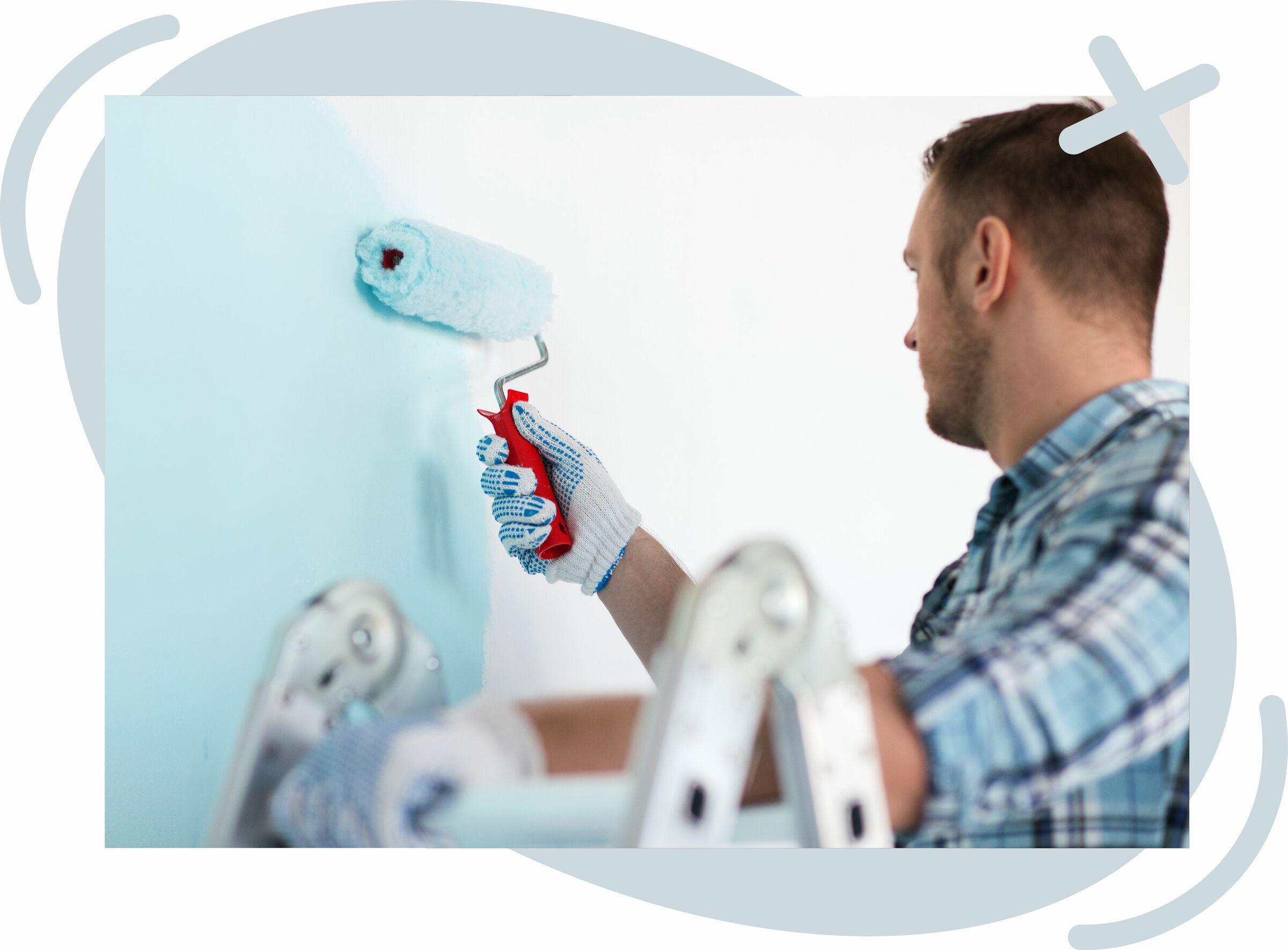 Person painting an interior wall light blue with a paint roller.
