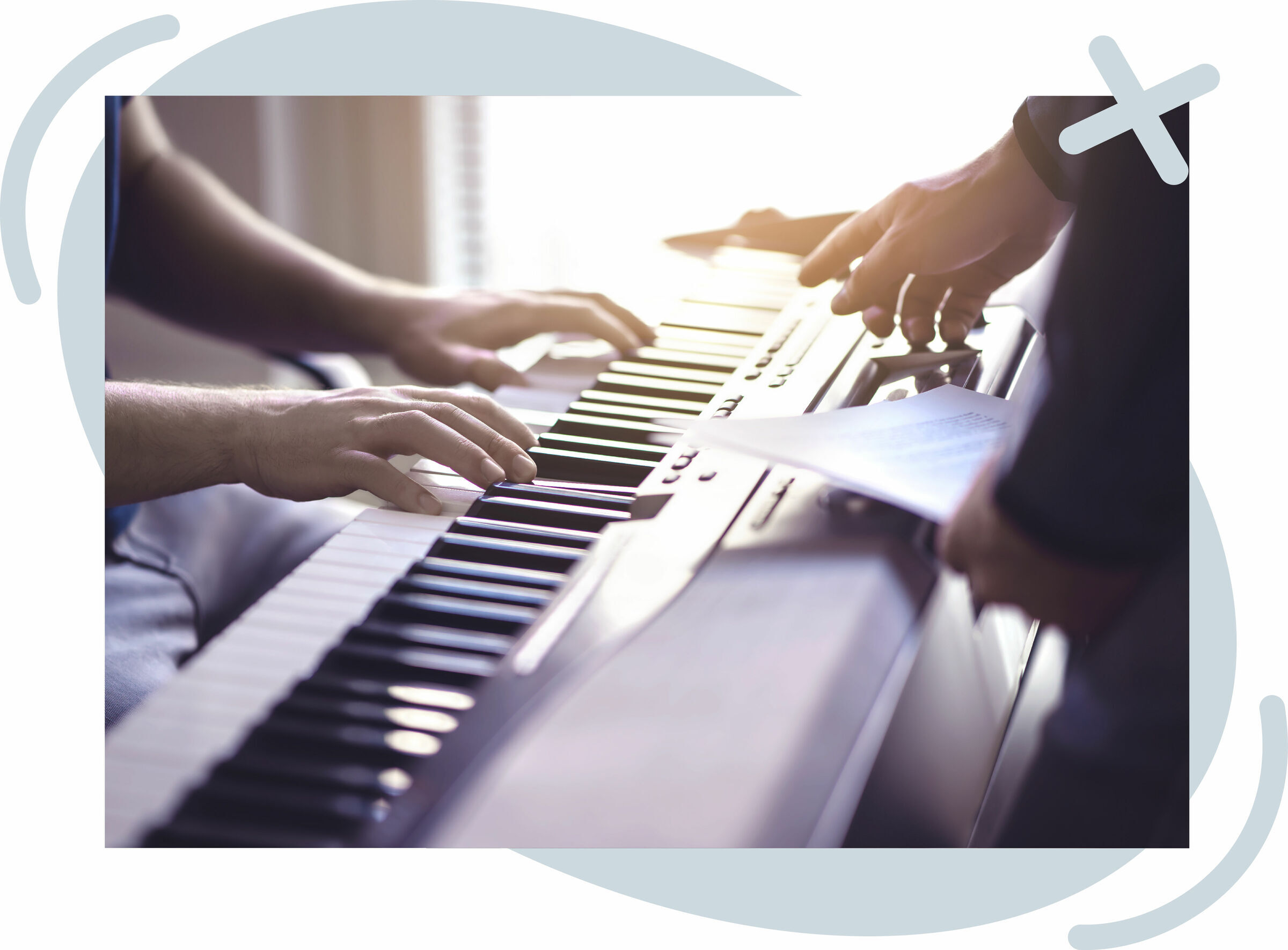 Close-up of two people at an electronic keyboard, one playing while the other holds sheet music and points at controls.