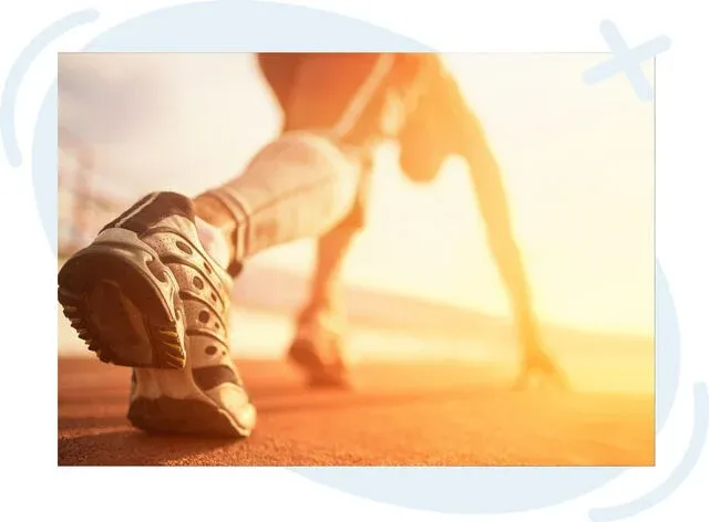 Close-up of a runner in a starting stance on a sunlit track, focus on one athletic shoe and forefoot poised to push off