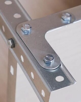 Close-up of a metal corner bracket assembly with bolts fastening perforated steel angles together.