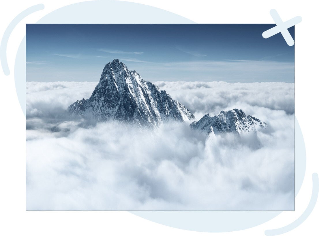 Snowy mountain peaks rising above a sea of clouds under a clear blue sky.