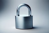 Close-up of a shiny silver padlock standing upright on a smooth, neutral background.