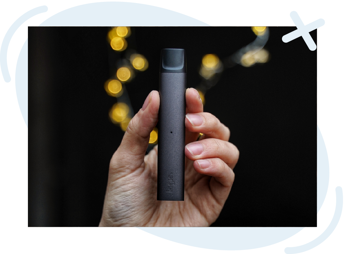 Hand holding a sleek vape pen against a dark background with warm bokeh lights, Smoke Shop product photo