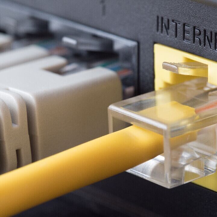 Close-up of a yellow Ethernet cable plugged into a router’s Internet port.