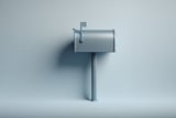 Minimalist photo of a silver metal mailbox on a post against a light gray background.