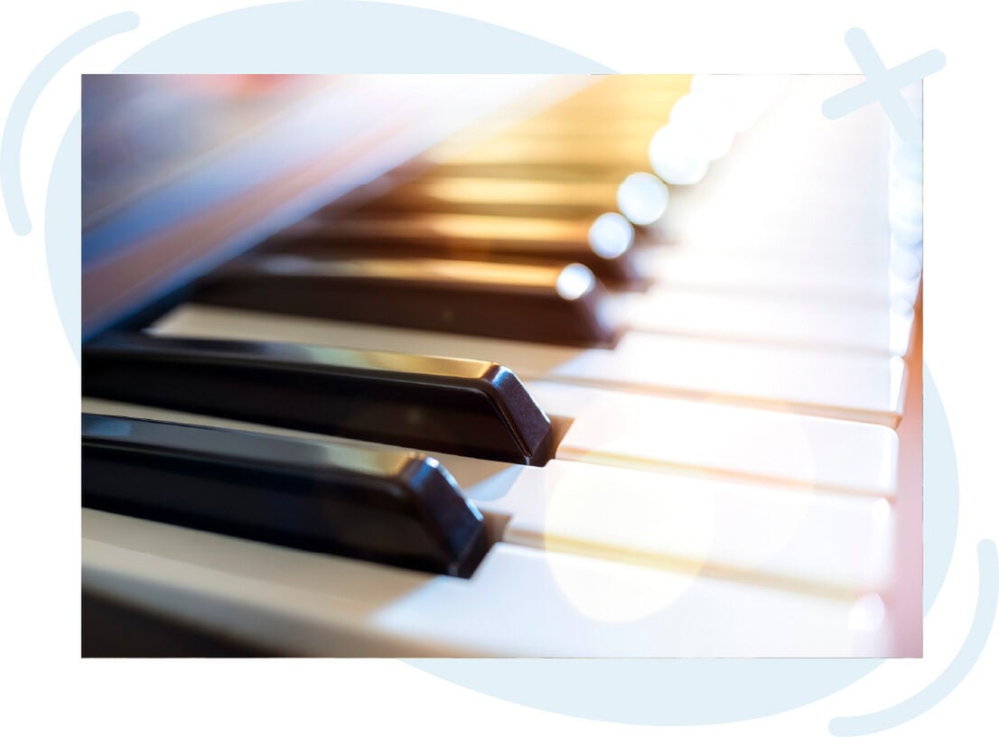 Close-up of piano keys with warm light flares at a music studio
