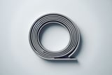 Coiled gray cable arranged in a neat spiral on a light gray surface, forming a circular shape with a small tail extending outward.