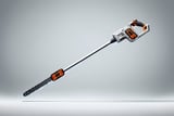 Long-handled electric pole saw with orange and black accents on a neutral background