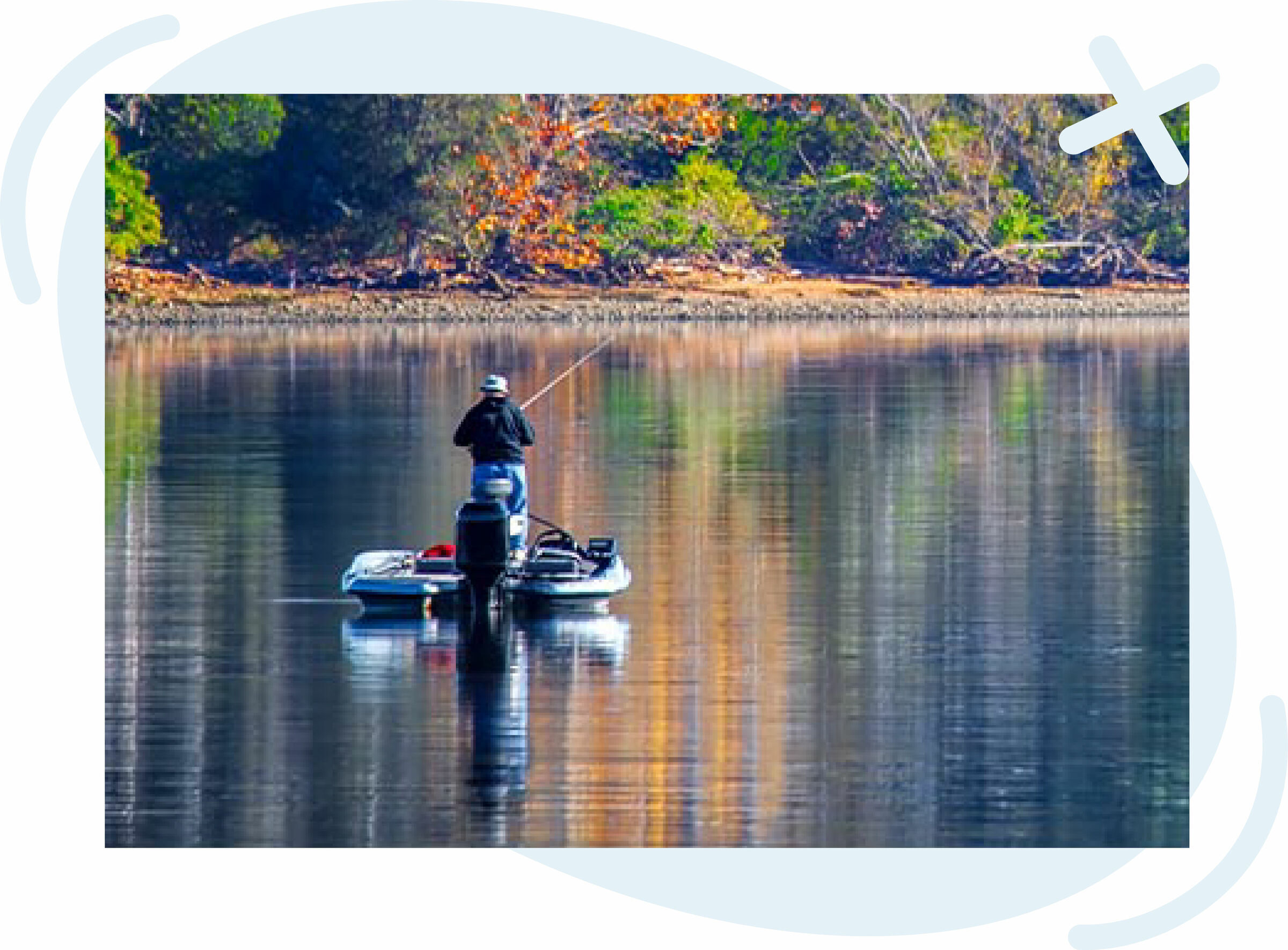 Person fishing from a small motorboat on a calm lake with colorful trees reflecting on the water.