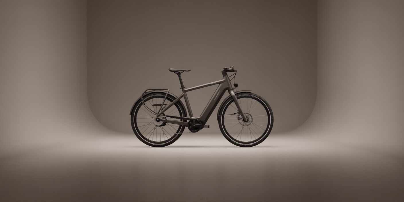 Side profile of a dark grey electric bicycle in a studio with a smooth grey infinity curve backdrop.