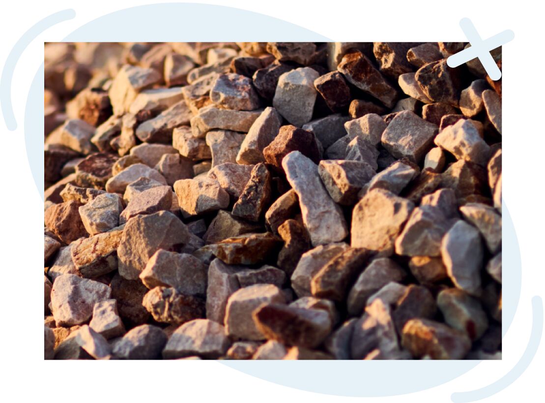 Close-up view of a pile of small, angular rocks lit by warm sunlight.