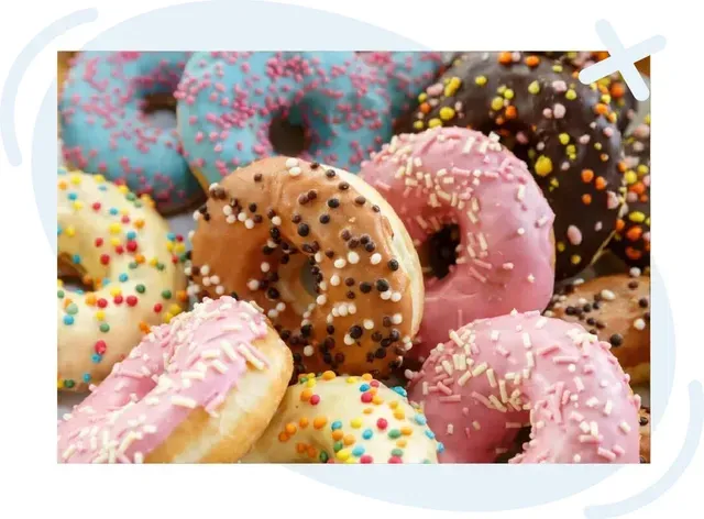 Pile of assorted donuts with colorful icing and sprinkles.