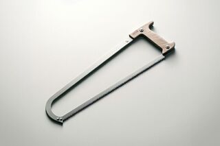 Minimalist photo of a bow saw with a wooden handle and a thin metal frame on a light gray background.