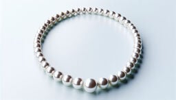 Elegant pearl necklace arranged in a circle on a pale surface