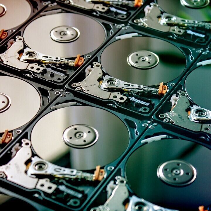 Grid of open hard disk drives with exposed platters and read-write arms