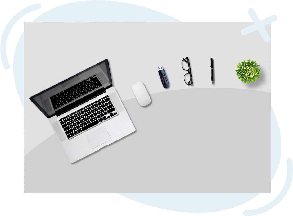 Minimal desktop flat lay with open laptop, wireless mouse, USB drive, eyeglasses, pen, and small potted plant on a light gray surface.