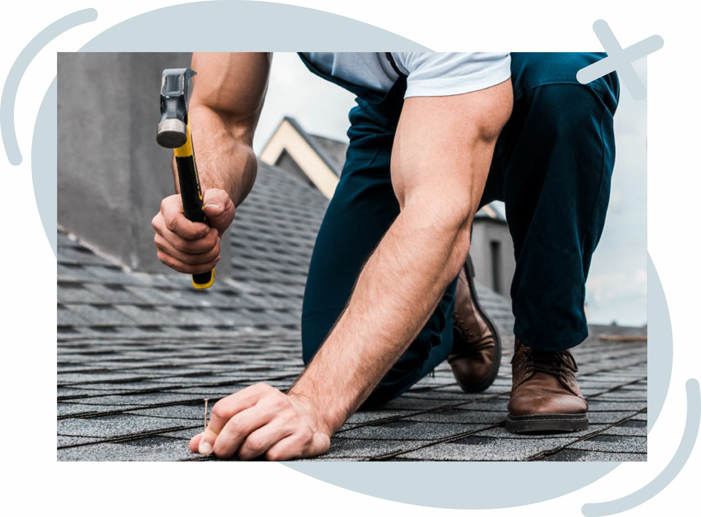 Close-up of a roofer kneeling on asphalt shingles, hammer in hand, nailing a shingle into place on a sloped roof.