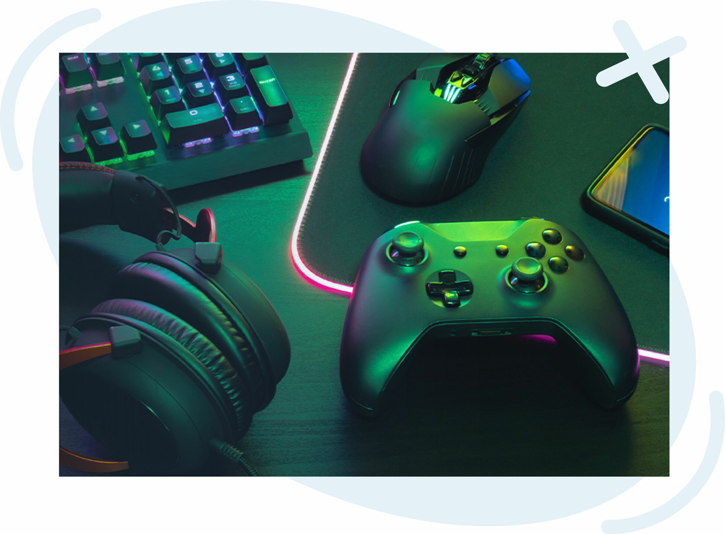 Desk setup with gaming gear: controller, mouse, keyboard, headset, and phone lit by RGB lighting.