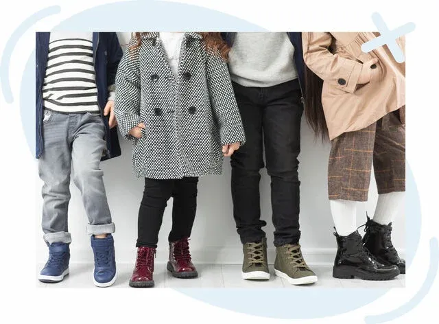 Four children standing side by side, shown from shoulders down, modeling stylish fall outfits with various boots and sneakers.